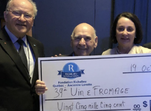 Trois personnes tenant un chèque de la part de la Fondation Richelieu Québec Ancienne-Lorette d'une valeur de 25500$ avec la mention 39 vin et fromage.