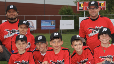 Jeunes joueurs et leurs 2 entraîneurs, tous vêtus au couleurs du club de baseball VBAL.