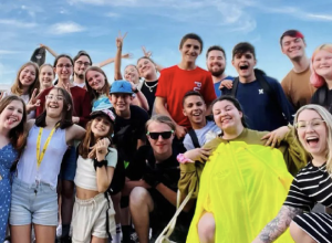Groupe de jeunes adolescents souriants devant un ciel bleu.