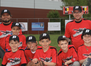 Jeunes joueurs et leurs 2 entraîneurs, tous vêtus au couleurs du club de baseball VBAL.